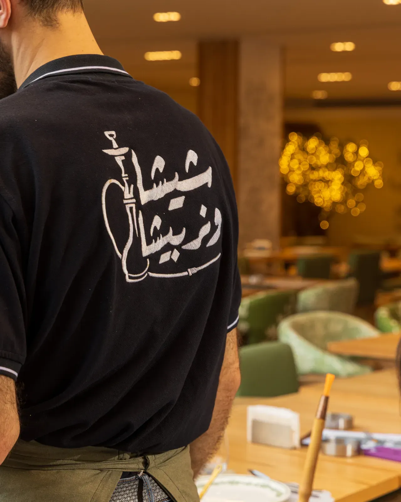 A shisha man in the team shirt, its back printed with a shisha in Arabic script