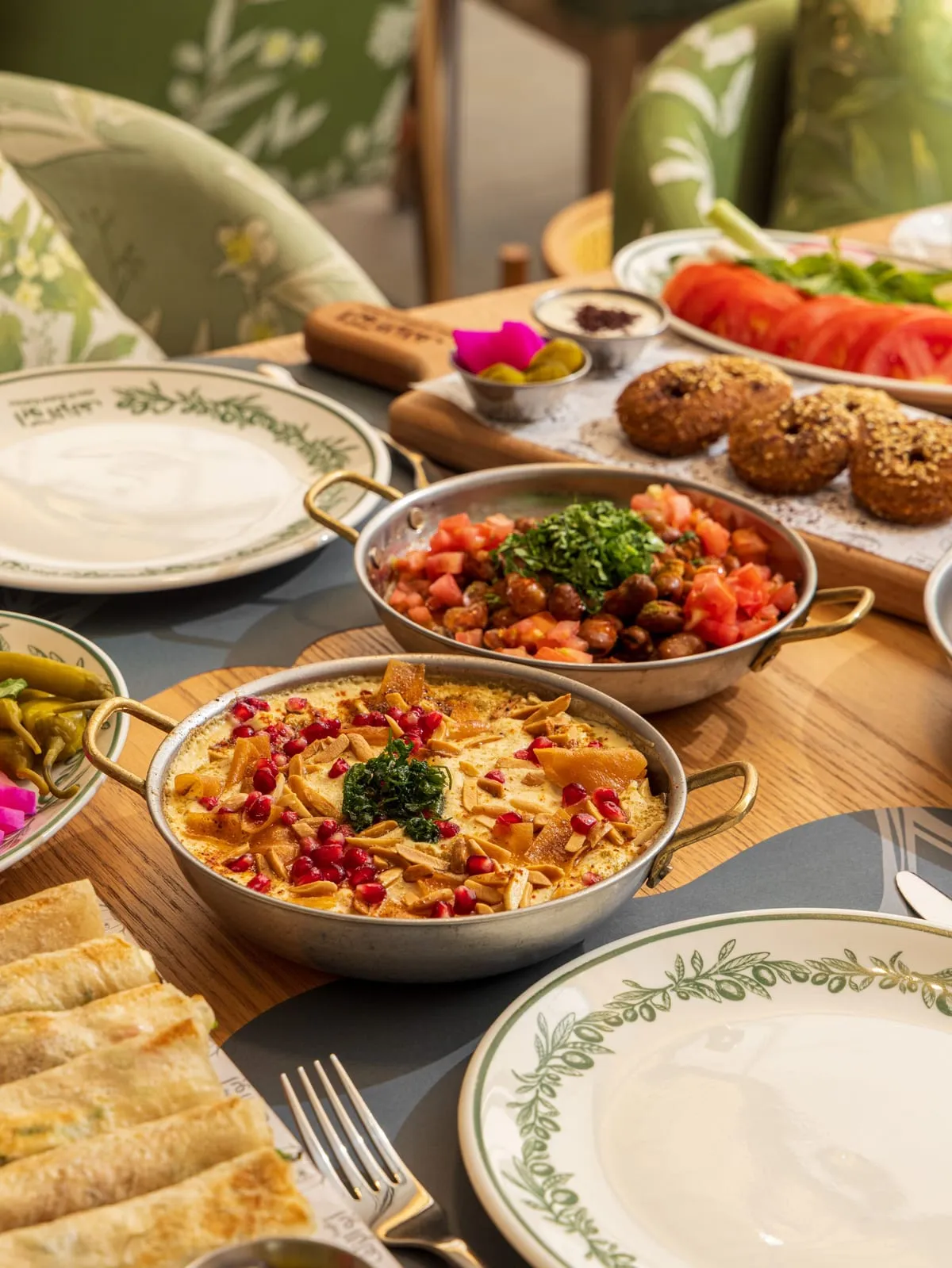 Pans of fatteh and stew among falafel, salads and rolled pastries
