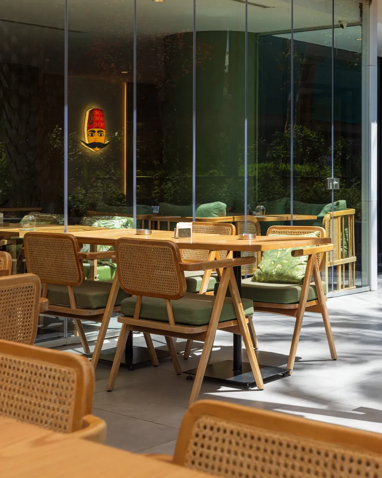 Rattan chairs by the glass wall of the terrace