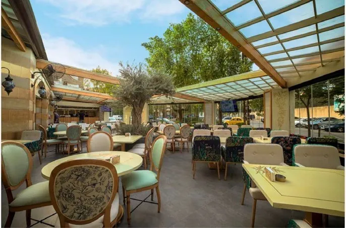 The first branch in Abu Rummaneh: a glass-roofed terrace around an olive tree